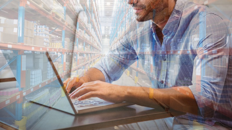 Un homme tape sur le clavier de son ordinateur.